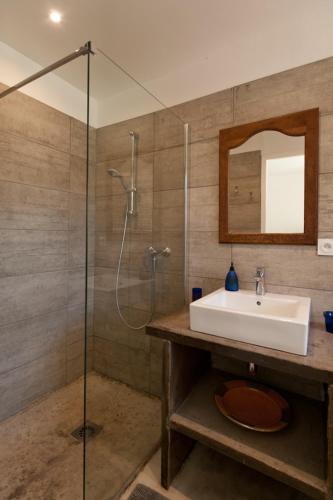 une salle de bain avec un lavabo et une douche en verre dans l'établissement Maison Tavolara, à Porto-Vecchio
