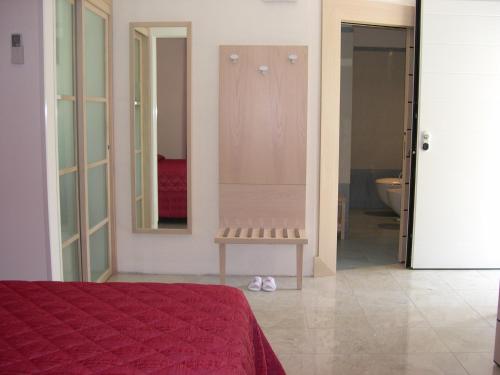 a bedroom with a bed and a mirror and a toilet at Hotel Bristol in Tirrenia
