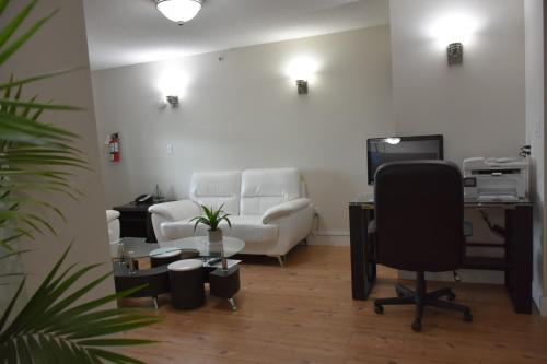 an office with a couch and a desk and a chair at Super 8 by Wyndham Fort McMurray in Fort McMurray