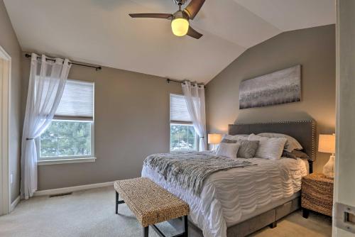 a bedroom with a bed with a ceiling fan and two windows at Bellefonte Townhouse - 9 Miles to Penn State! in Bellefonte