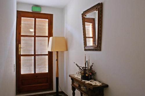 a room with a door and a table and a mirror at Casa Rural Cal Met in Sant Boi de Lluçanès