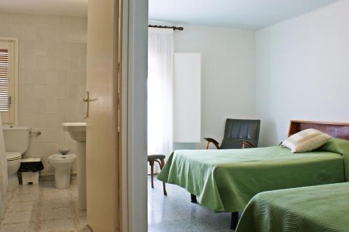 a room with two beds and a bathroom with a toilet at Casa Rural Cal Met in Sant Boi de Lluçanès
