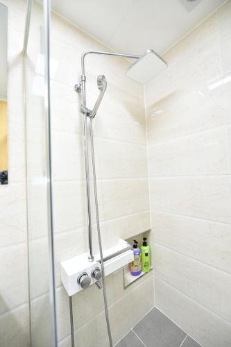 a shower with a glass door in a bathroom at Sokcho Daemyung Heidi Pension in Sokcho