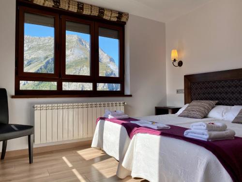a bedroom with a bed with a view of a mountain at Hotel La Cuna del Sella in Oseja de Sajambre