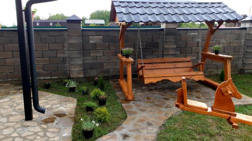 a wooden bench in a garden with a gazebo at Садиба For Rest in Svityazʼ