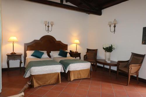 a bedroom with two beds and a table and chairs at Hotel Villa Lampedusa in Palermo