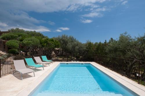 a swimming pool with lounge chairs next to a swimming pool at Maison Tavolara in Porto-Vecchio