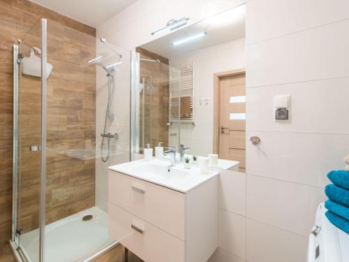 a bathroom with a sink and a shower at Seashell Apartment in Kołobrzeg