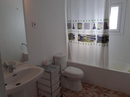 a bathroom with a sink toilet and a shower curtain at Villapreciosa in Peñíscola