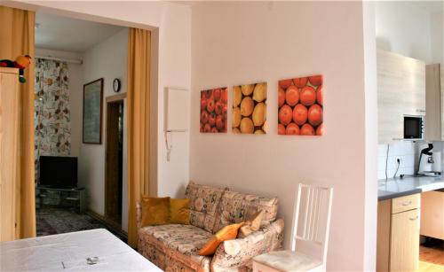 ein Wohnzimmer mit einem Sofa und Gemälden an der Wand in der Unterkunft Kleiner Herrenhof in Worms
