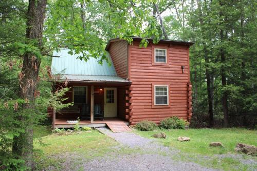 a red cabin in the middle of the woods at Country Road Cabins in Hico