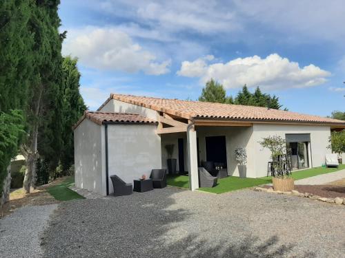 a small white house with a garage at La Villa Claudia Jardin et Spa in Pennautier