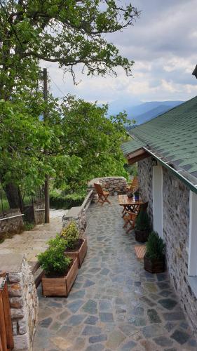a patio with benches and tables on a house at The House in the Cobbled Road in Karpenision