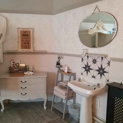 a bathroom with a sink and a mirror at Rigsbys Guesthouse Doncaster in Doncaster