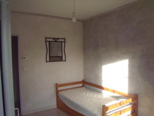 une chambre avec un lit et un miroir au mur dans l'établissement petite touche, à Courdemanche