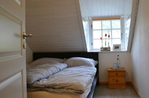 a bed in a small room with a window at Bioland Hof Bockmann in Bordesholm