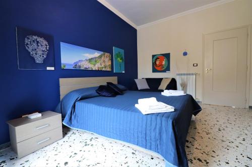 una camera blu con un letto e una TV a parete di Painter House a Sant'Agnello