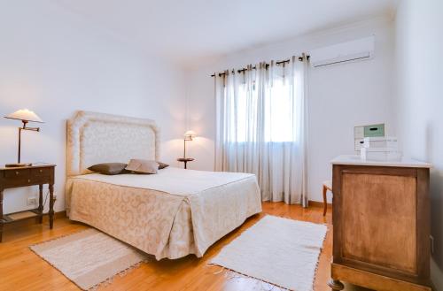 een slaapkamer met een bed, een dressoir en een raam bij Mango Apartment - Faro city center in Faro