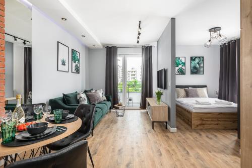 a living room with a couch and a bed at PREMIUM Apartments New Town Private Parking Included in Szczecin