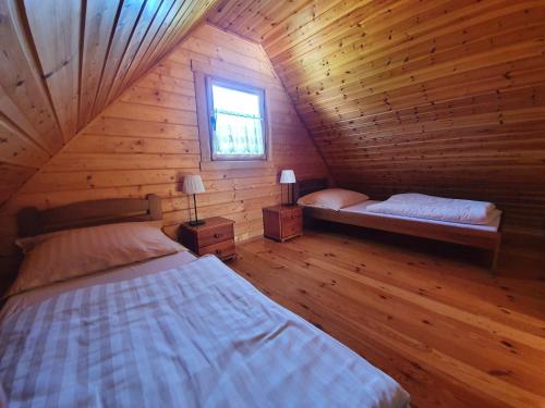 a bedroom with two beds in a wooden cabin at Anna i Halina in Sztutowo