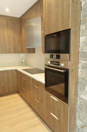 a kitchen with a stove and a microwave at Olden Panorama Apartments - Fjord view - High Standard in Olden