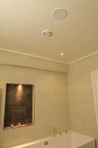 a bathroom with a bath tub and a window at Olden Panorama Apartments - Fjord view - High Standard in Olden