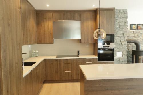 a kitchen with wooden cabinets and a white counter top at Olden Panorama Apartments - Fjord view - High Standard in Olden