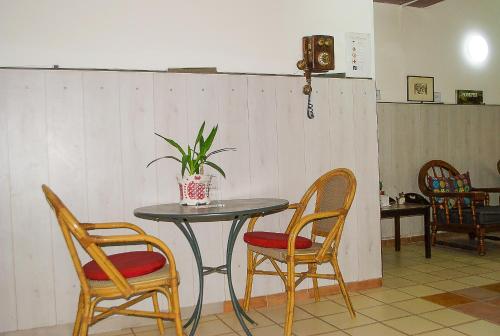 a table with two chairs and a table with a plant on it at B&B Cappotto civico 48 in Pompei