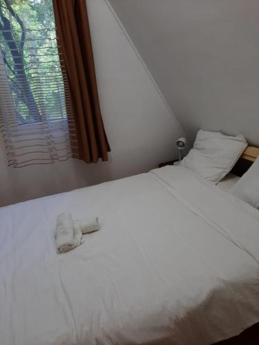 a white bed with two towels on top of it at Cabana din livada cu ciubar in Pucioasa