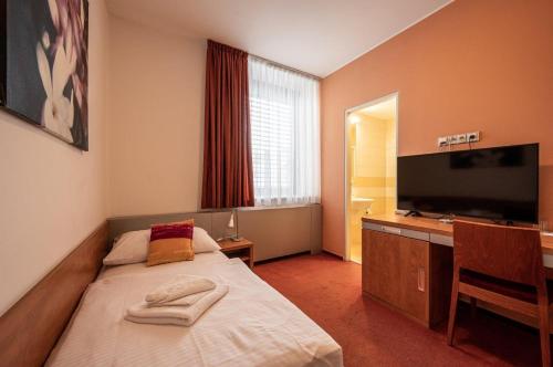 a bedroom with a bed and a flat screen tv at Ruby Blue in Ostrava