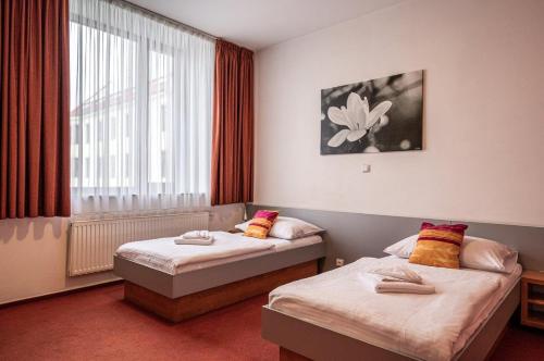 a hotel room with two beds and a window at Ruby Blue in Ostrava