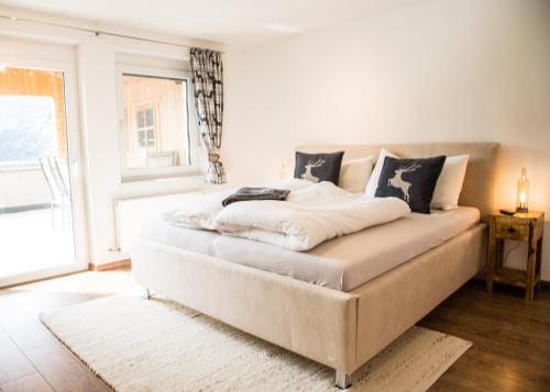 a bedroom with a large white bed with a window at Bergjuwel in Nassereith
