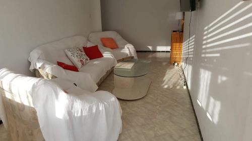 Apart 2 habit vistas playa y montaña lift parking في كليلة: غرفة معيشة مع كنبتين بيضاء وطاولة