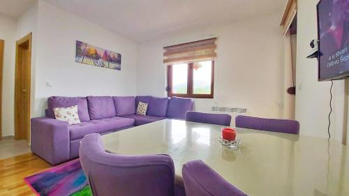 a living room with a purple couch and a table at Nirvana 06 in Zlatibor