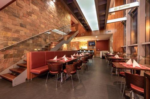 a restaurant with tables and chairs and a staircase at Ruby Blue in Ostrava