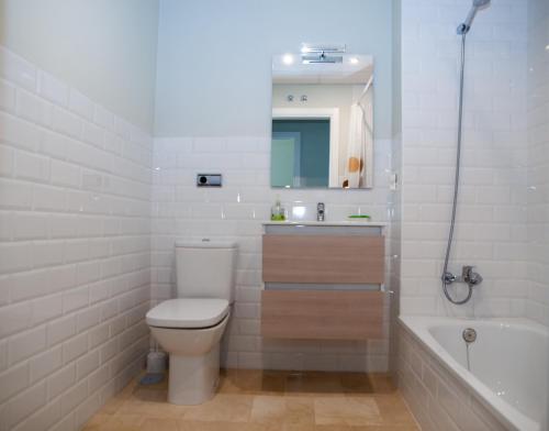 a bathroom with a toilet and a sink and a tub at La Casa del Arte in Cádiz