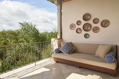 a couch on a balcony with plates on the wall at Rancho Santana in El Limón