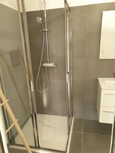 une douche avec une porte vitrée dans une salle de bain dans l'établissement Appartement 2 pièces dans le centre historique de Porto Vecchio, à Porto-Vecchio