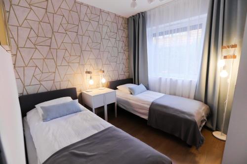 Una habitación de hotel con dos camas y una ventana. en M&K Apartament Moc Natury Sobieszewo - Wyspa Sobieszewska, en Gdansk