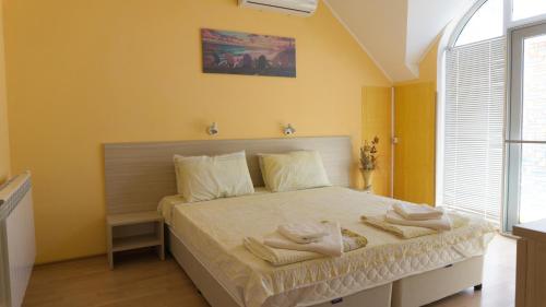 a bedroom with a bed with two towels on it at Guest House Gardeli in Tsarevo
