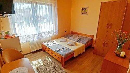 a small bedroom with a bed and a window at Pensjonat Koral in Darłówko