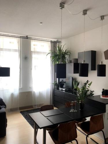 a dining room with a black table and chairs at Gemütliche 2 Zimmer Wohnung neben der Burg in Kröllwitz