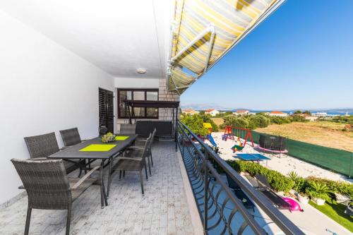 a balcony with a table and chairs and a beach at Villa Olivia Trogir in Trogir