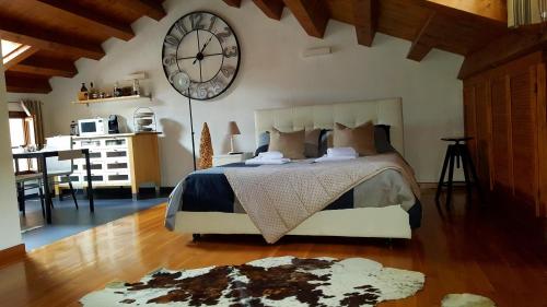 1 dormitorio con 1 cama con reloj grande en la pared en Torre Cà Emo - Dormire a Serravalle, en Vittorio Veneto