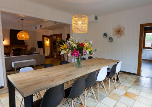 a dining room table with a vase of flowers on it at Vakantiehuis Elisa in Alken