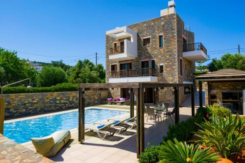 a villa with a swimming pool and a house at La Casa di Pietra Villas in Agios Nikolaos
