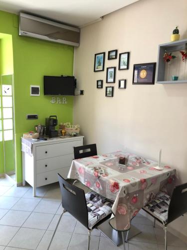 una sala da pranzo con tavolo, sedie e pareti verdi di Casa vacanza dei Greci a Barletta