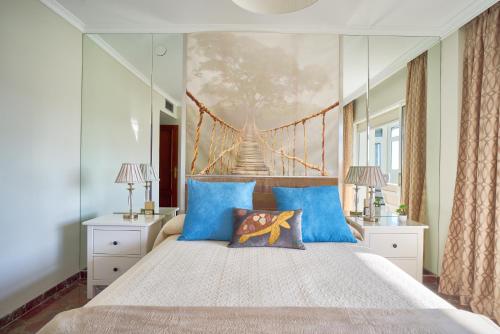 ein Schlafzimmer mit einem großen Bett mit blauen Kissen in der Unterkunft Apartamento Málaga City Center in Málaga