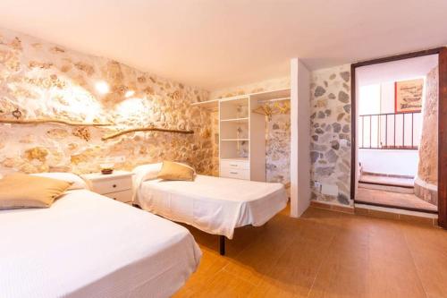 a bedroom with two beds and a window at Molí D,en Barret in Santa Margalida