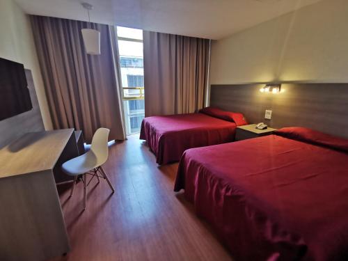 Cette chambre comprend deux lits et une télévision. dans l'établissement Hotel Del Angel Reforma, à Mexico